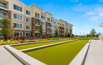 An exterior view of an apartment building with a green lawn